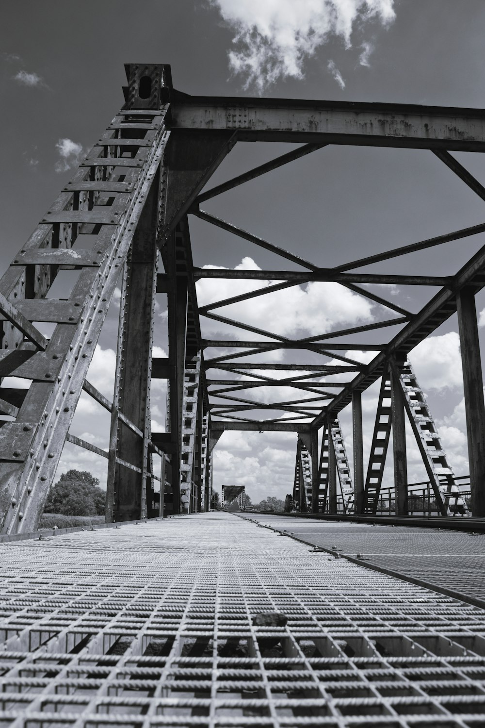 a black and white photo of a metal bridge