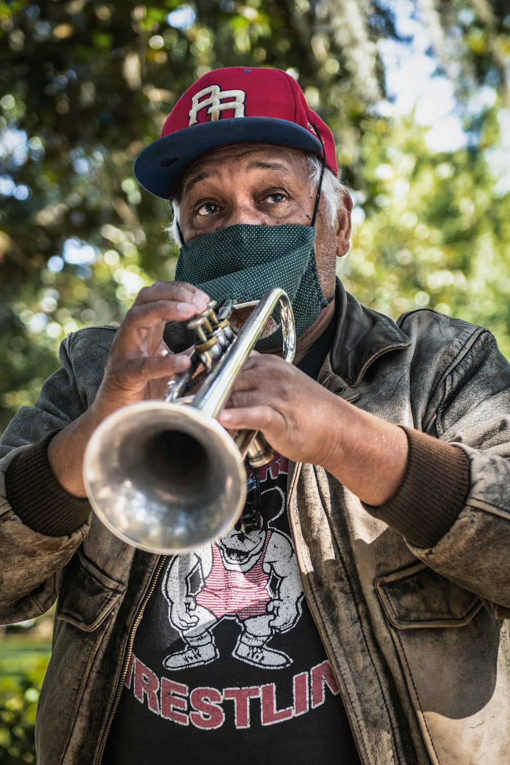 a man with a bandana on his face playing a trumpet