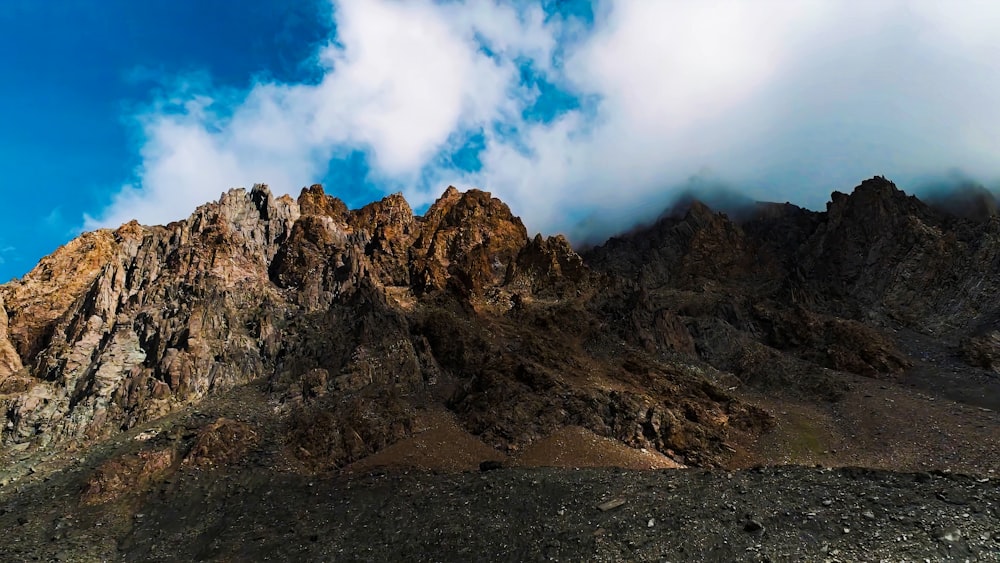 a very tall mountain with some clouds in the sky