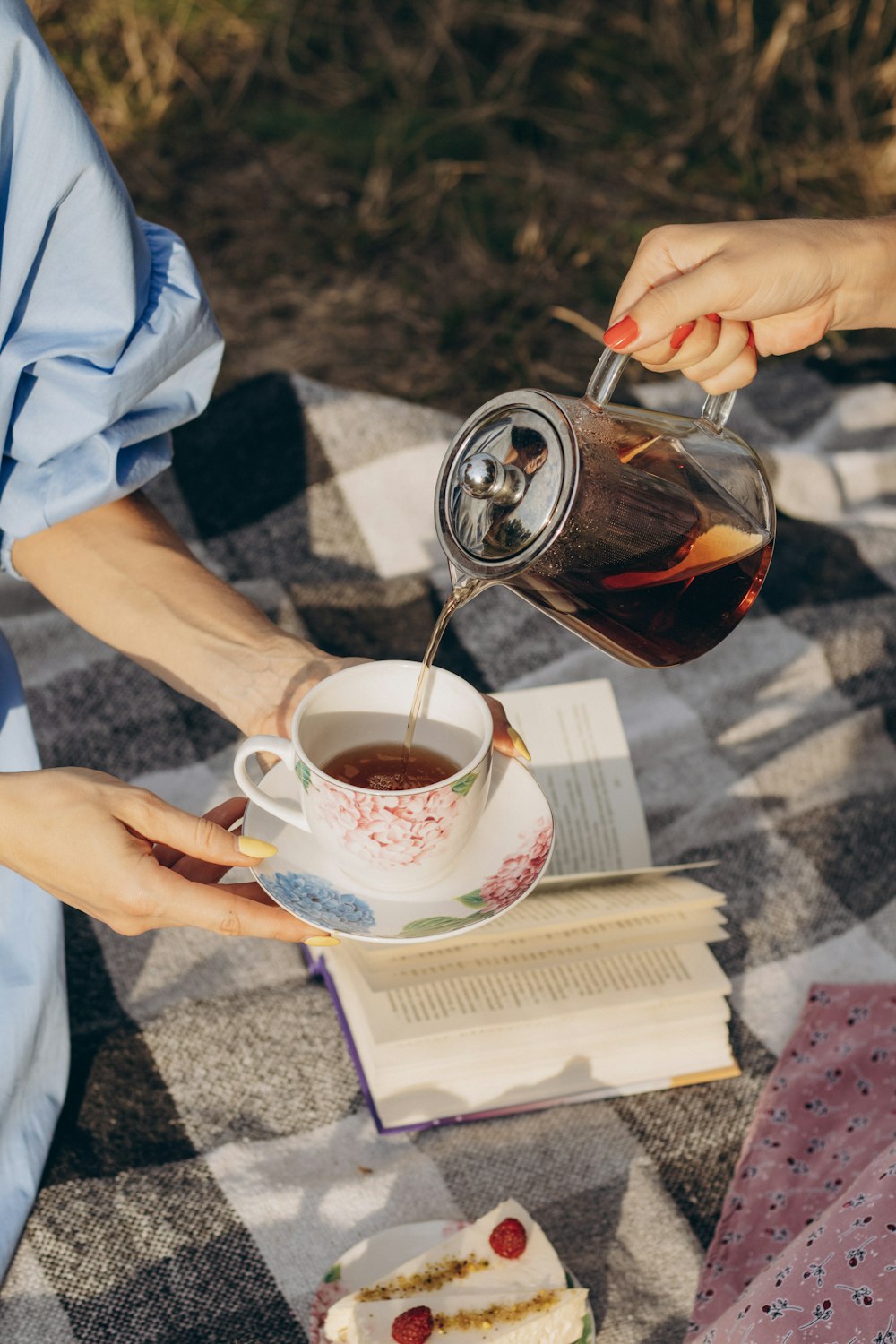 a woman is pouring tea into a cup