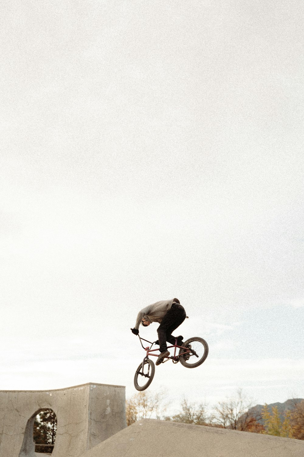 a man riding a bike up the side of a ramp