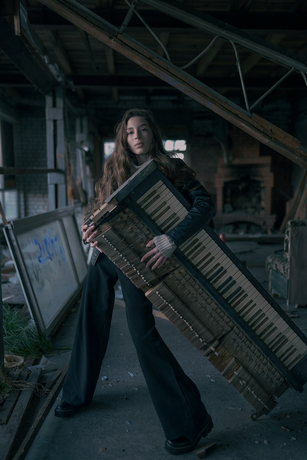 a woman carrying a large wooden instrument in a warehouse