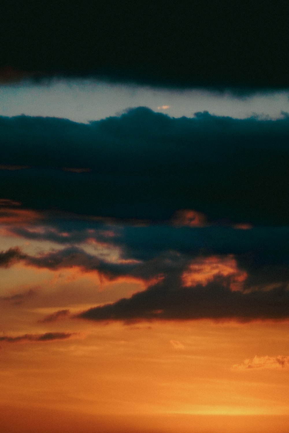 a plane flying in the sky at sunset