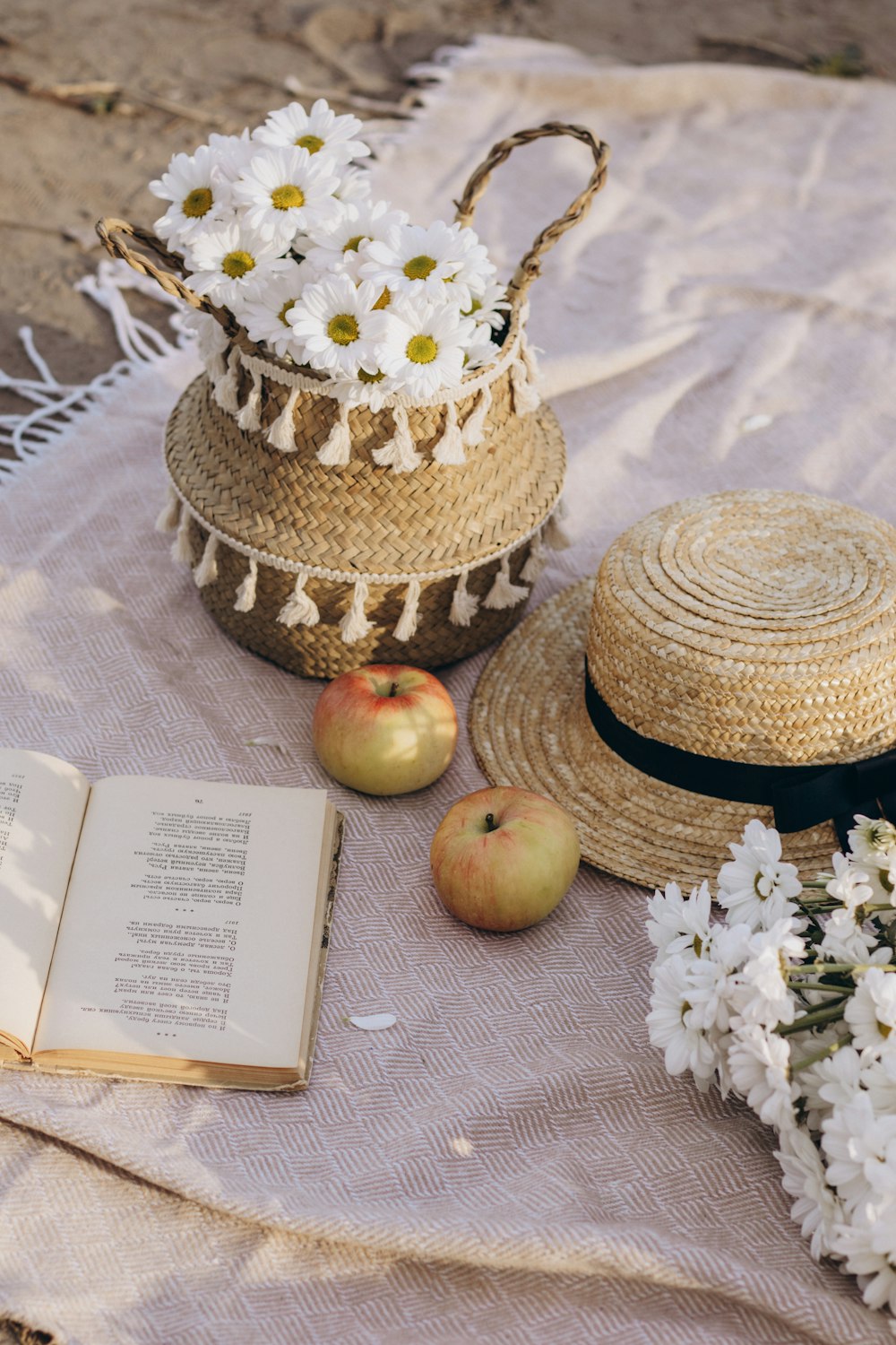 uma mesa coberta com um livro e duas cestas cheias de flores