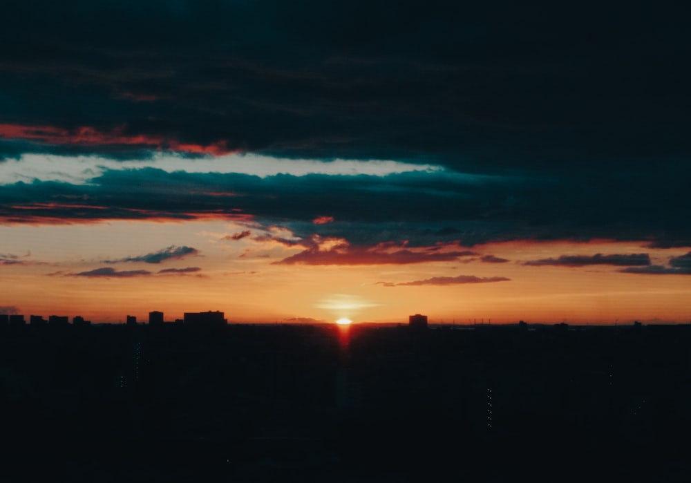 the sun is setting over a city skyline