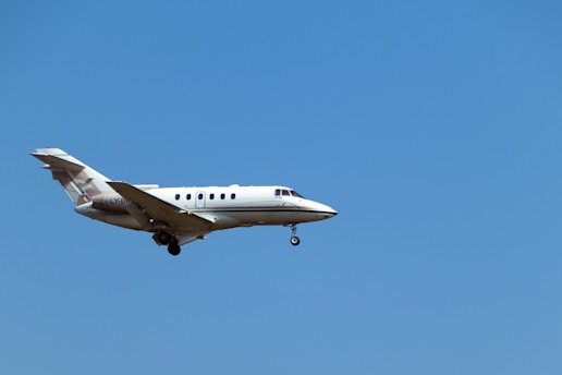 a white airplane flying in a blue sky