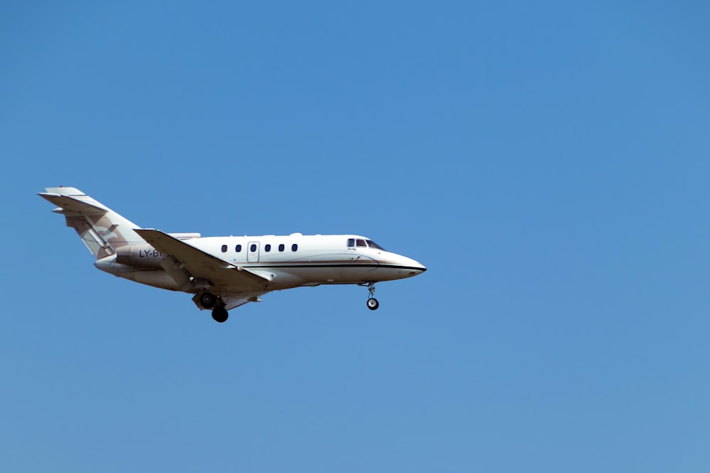 a white airplane flying in a blue sky