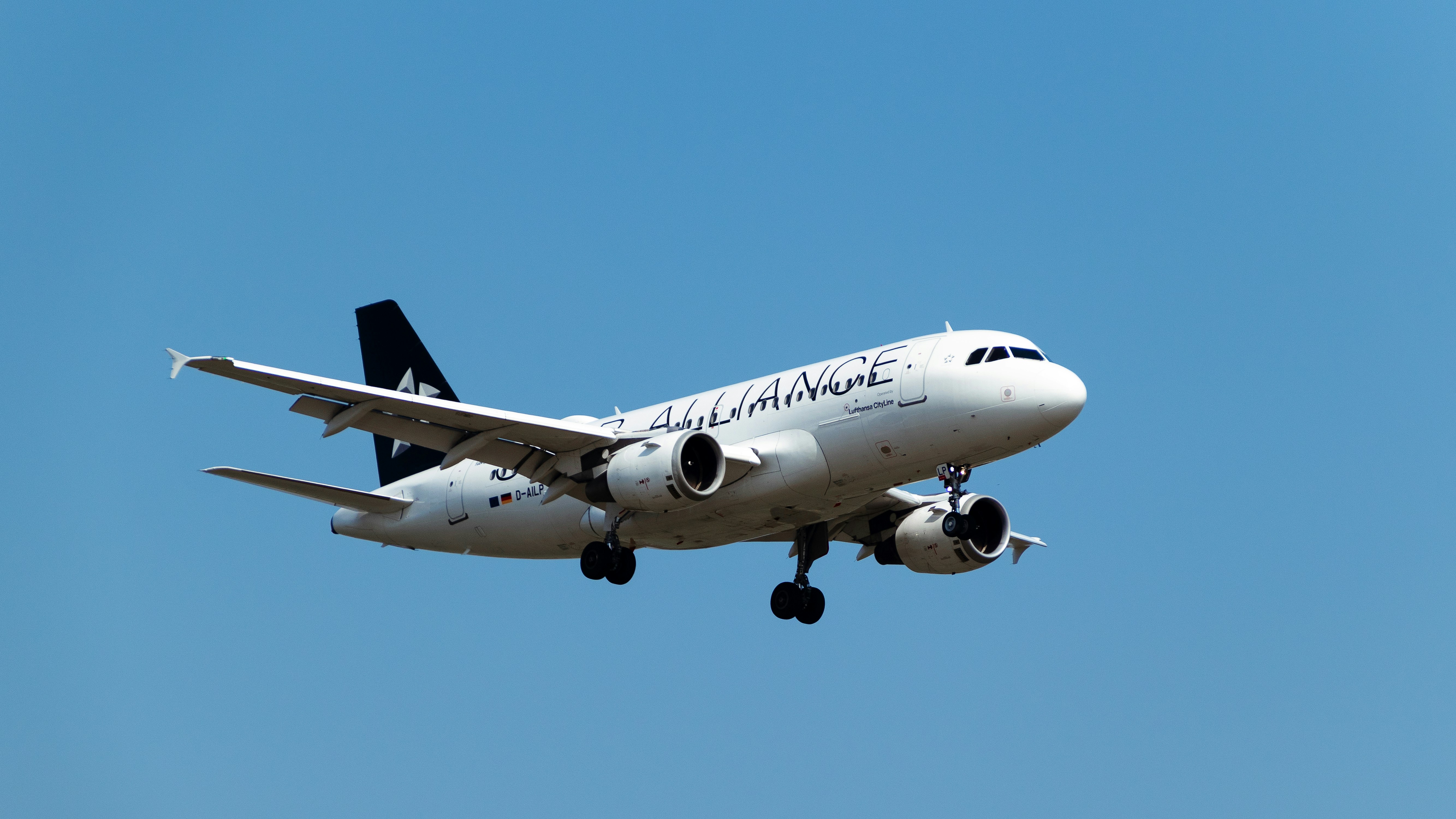 a large jetliner flying through a blue sky, 
