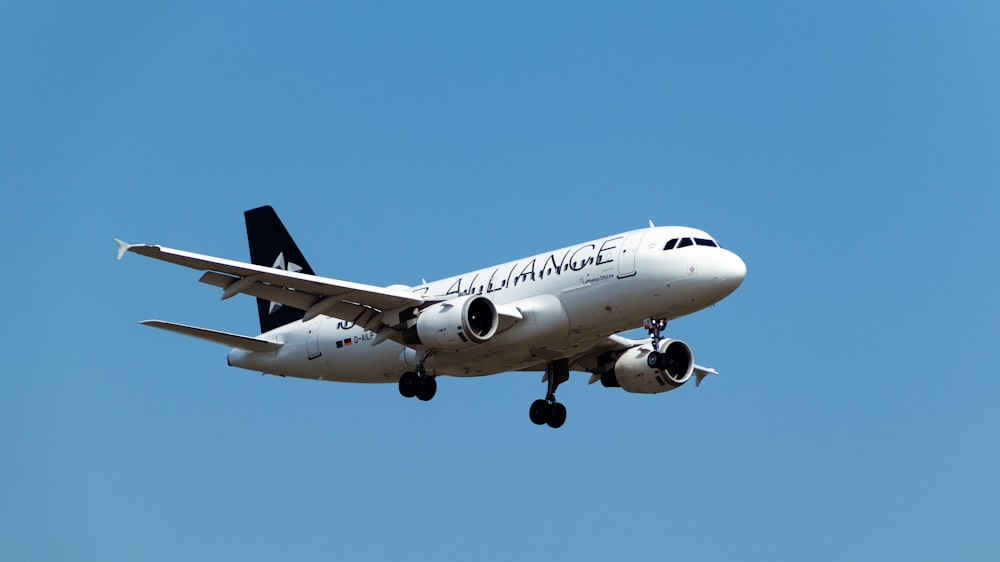 a large jetliner flying through a blue sky