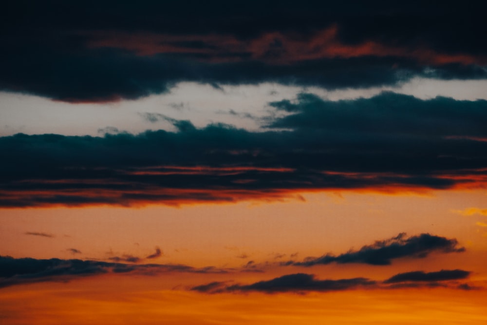 a plane flying in the sky at sunset