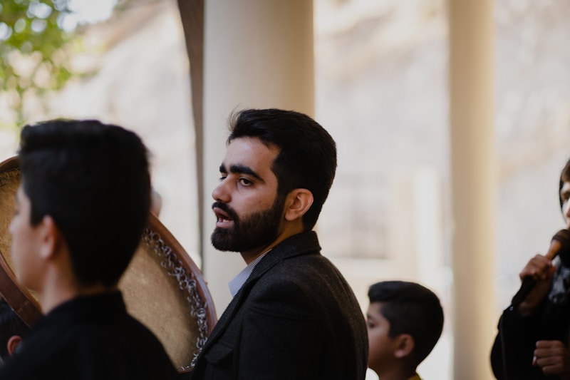 a man with a beard standing in front of a mirror