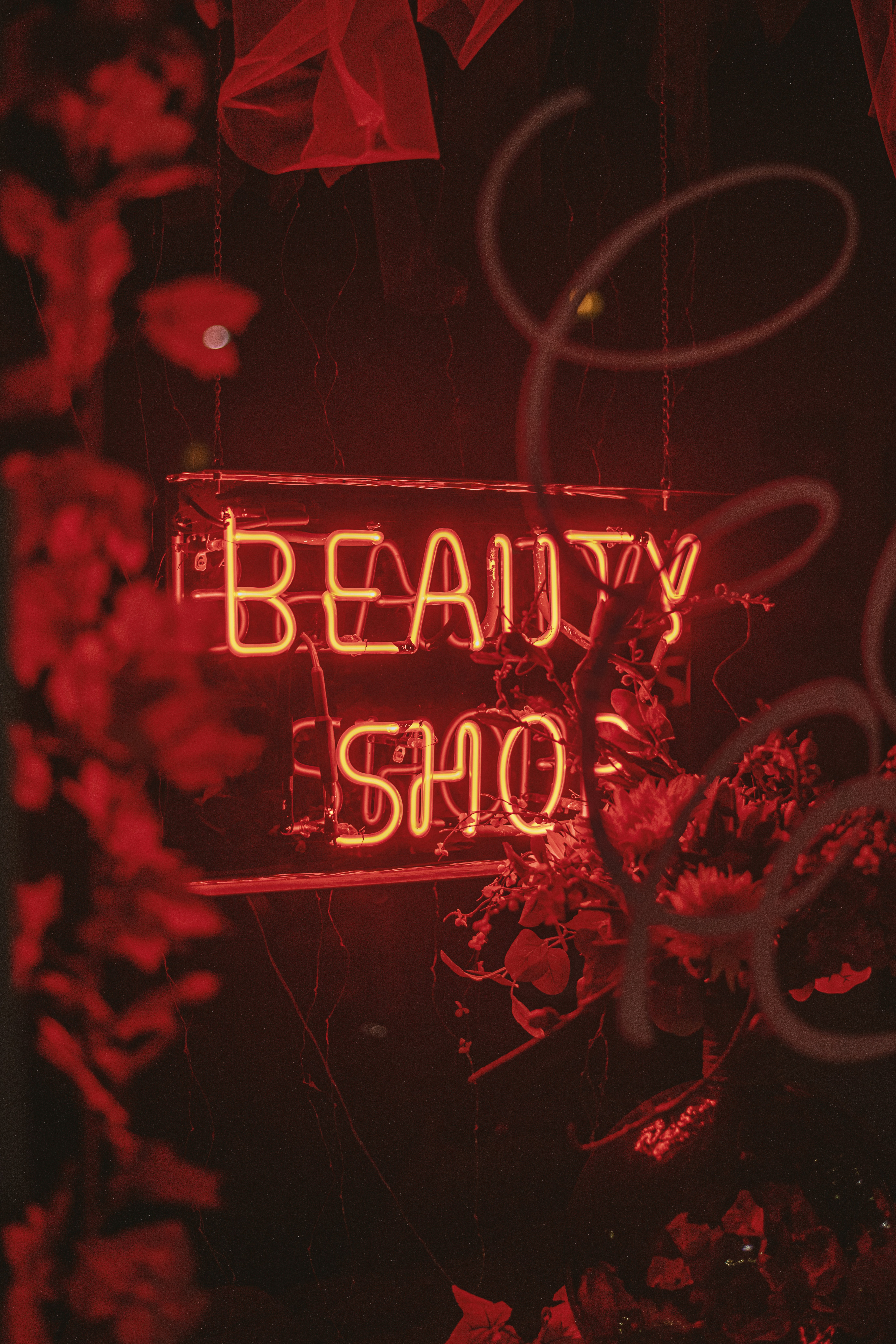 a red neon sign that says beauty shop