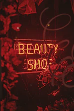 a red neon sign that says beauty shop