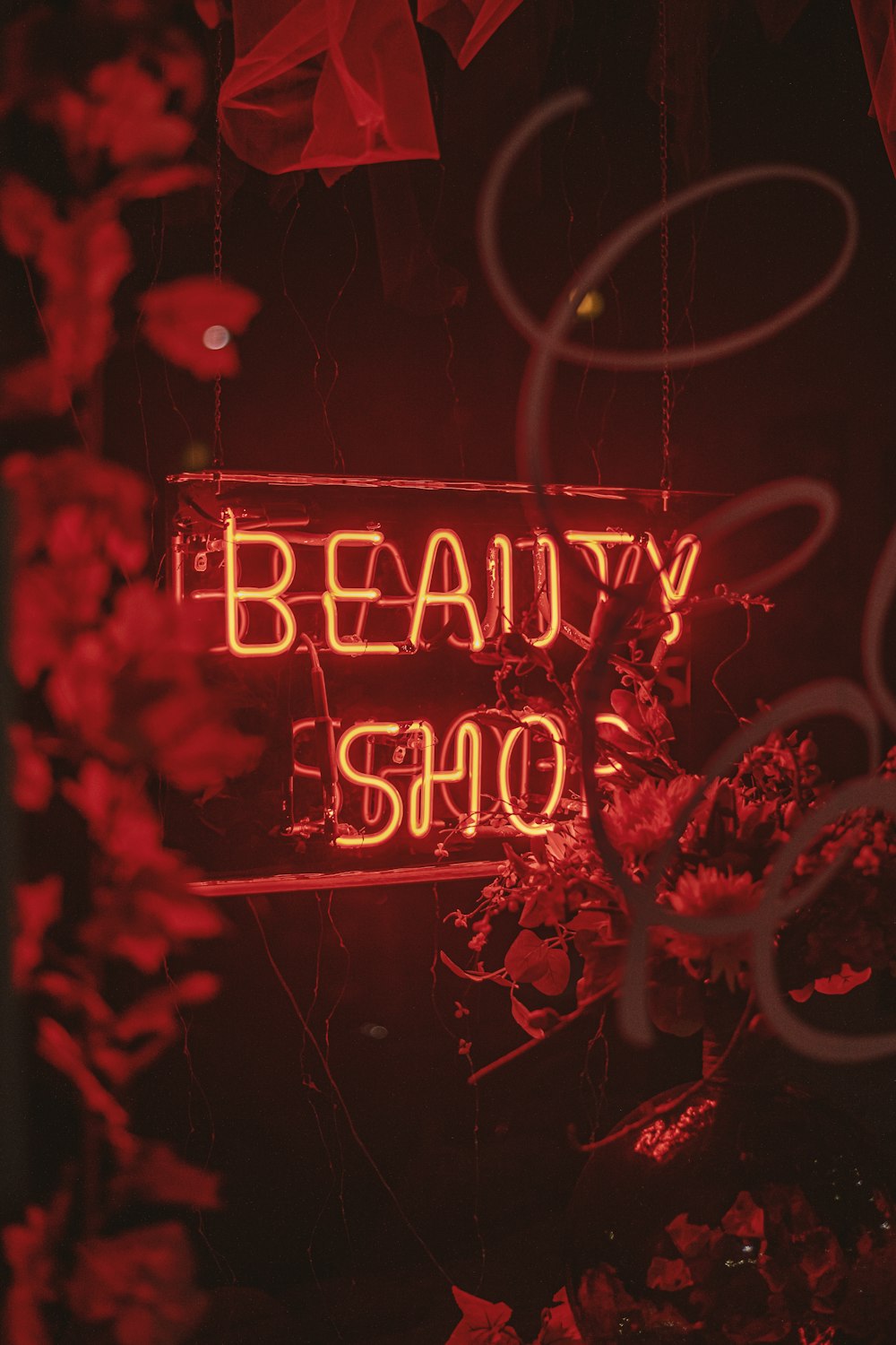 a red neon sign that says beauty shop