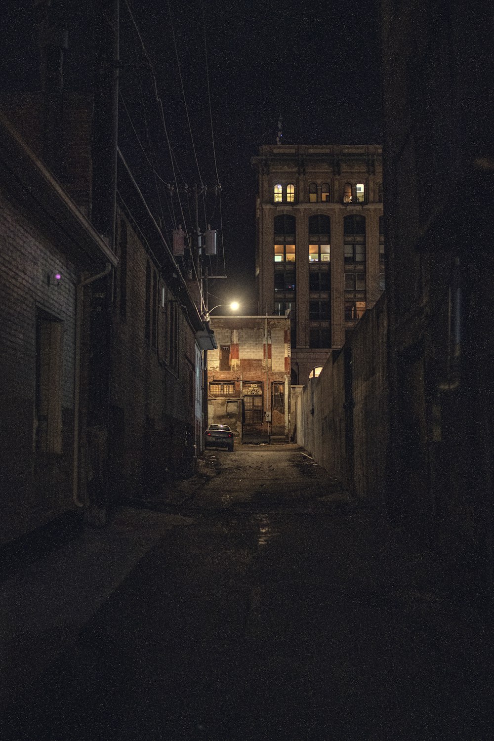 a dark alley way with a building in the background