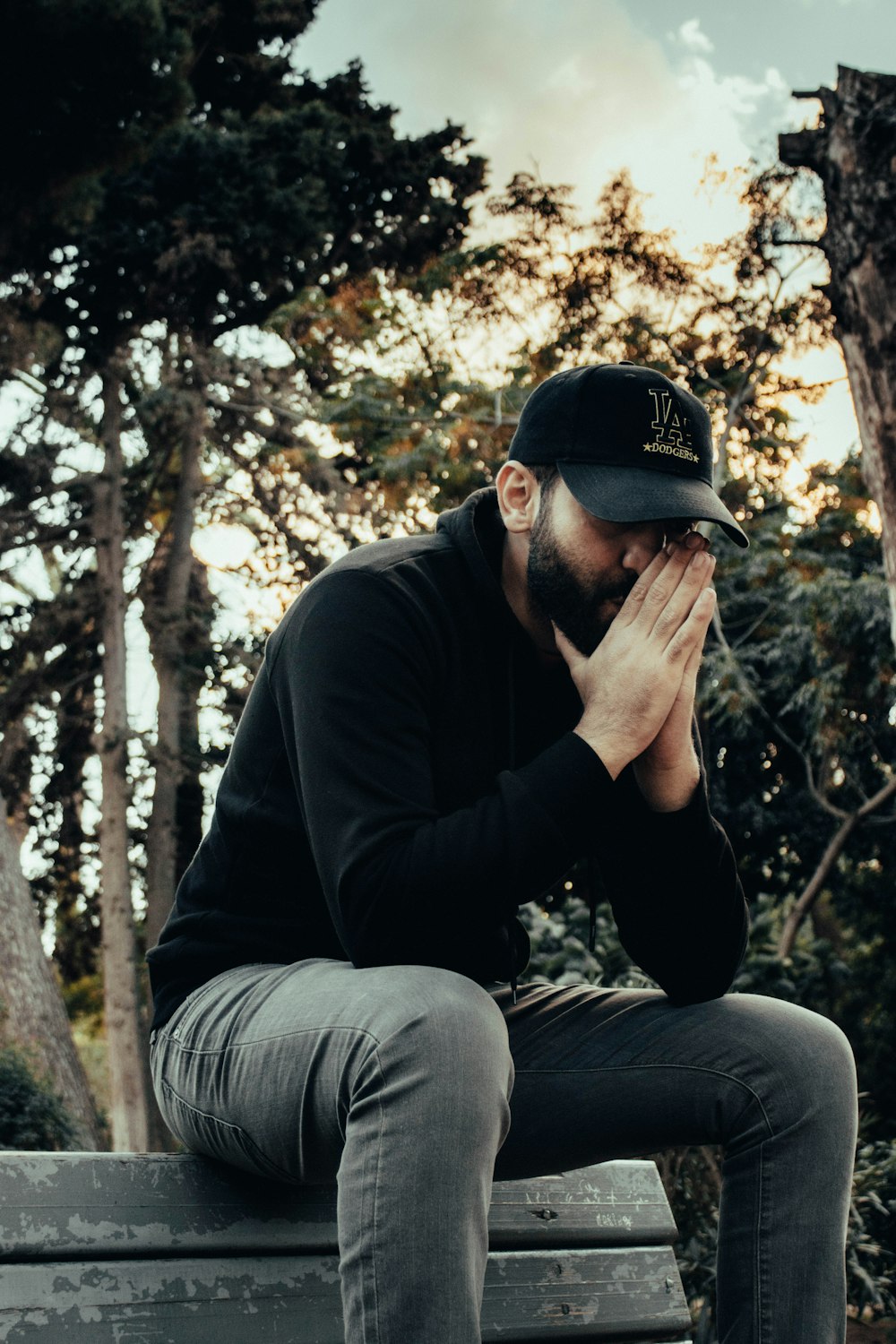 a man sitting on top of a wooden bench