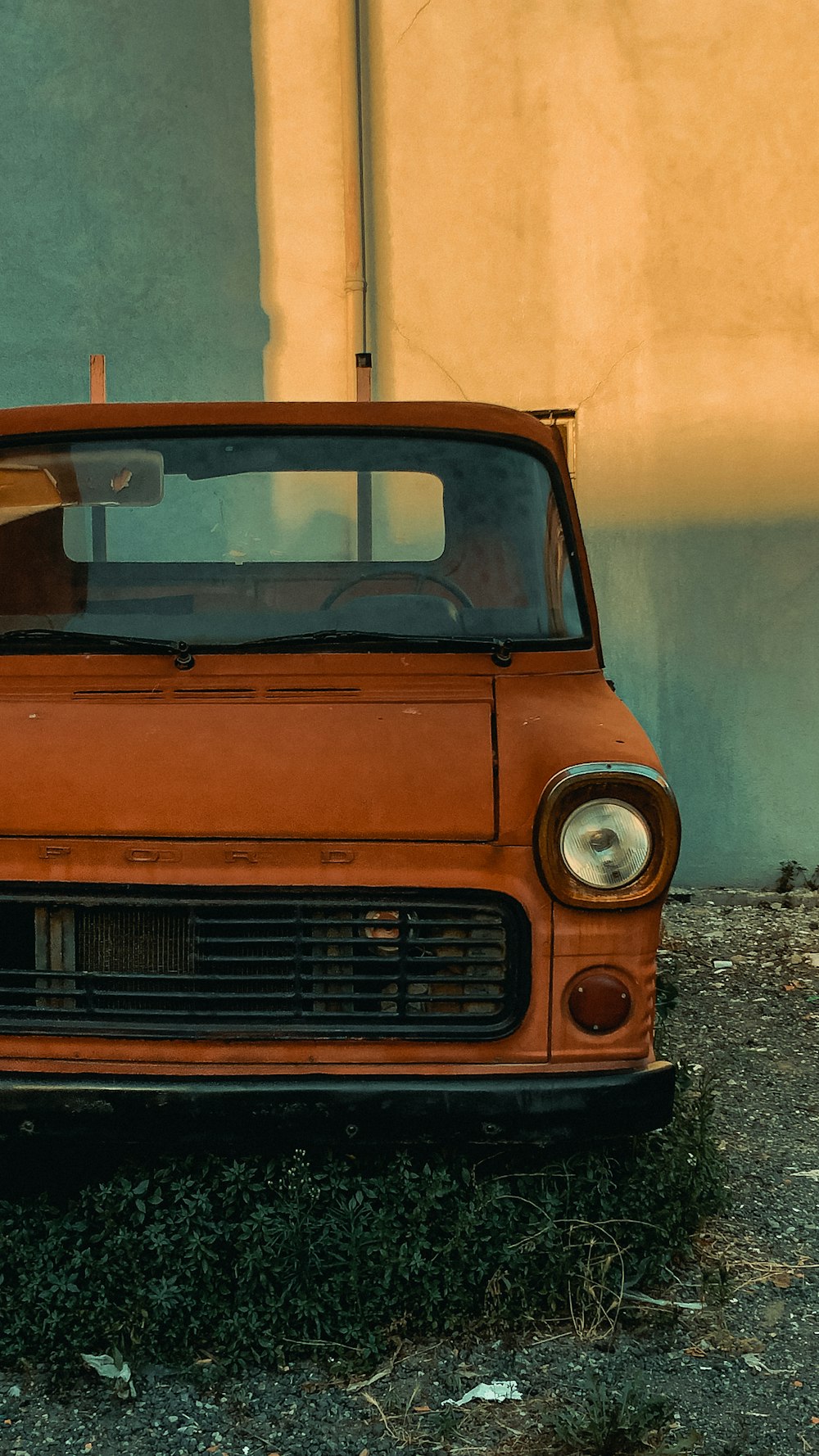 an old orange truck parked in front of a building