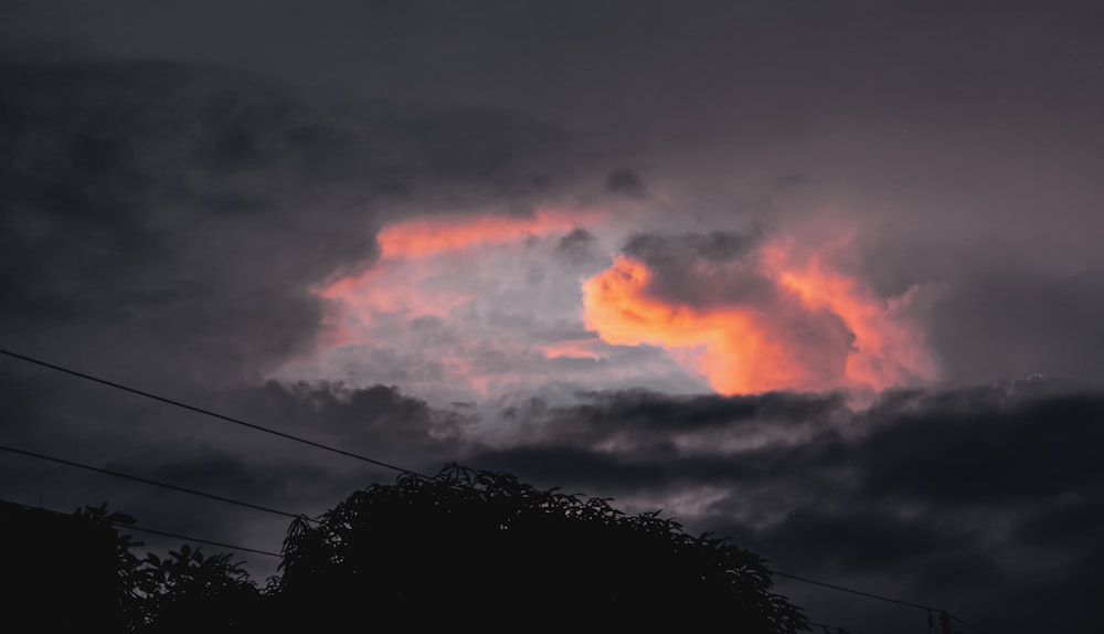 a dark sky with a pink cloud in the middle of it