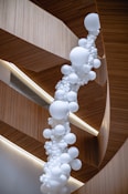 a bunch of white balloons hanging from a ceiling
