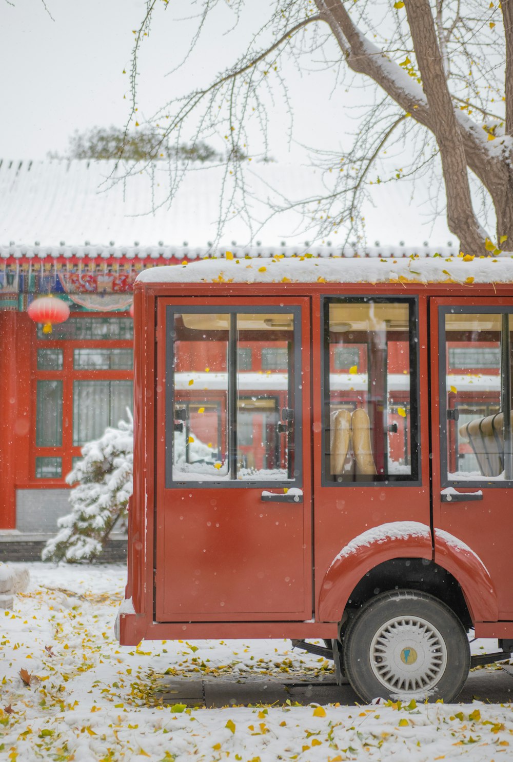 a red bus is parked in the snow