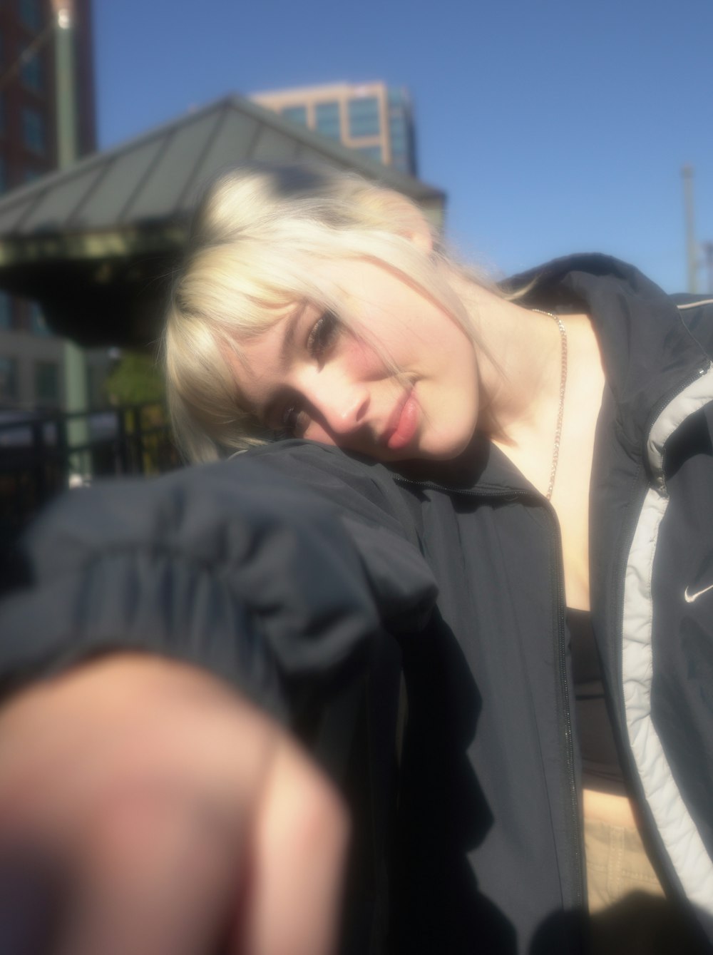 Eine Frau mit blonden Haaren, die eine schwarze Jacke trägt