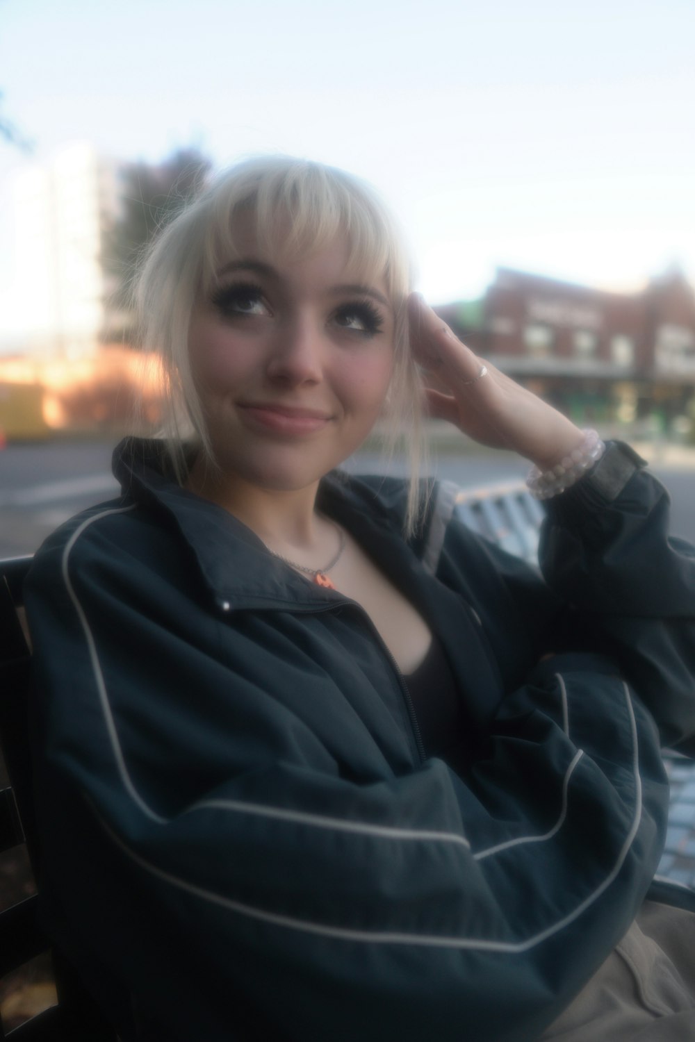 a woman sitting on a bench with her hand on her head