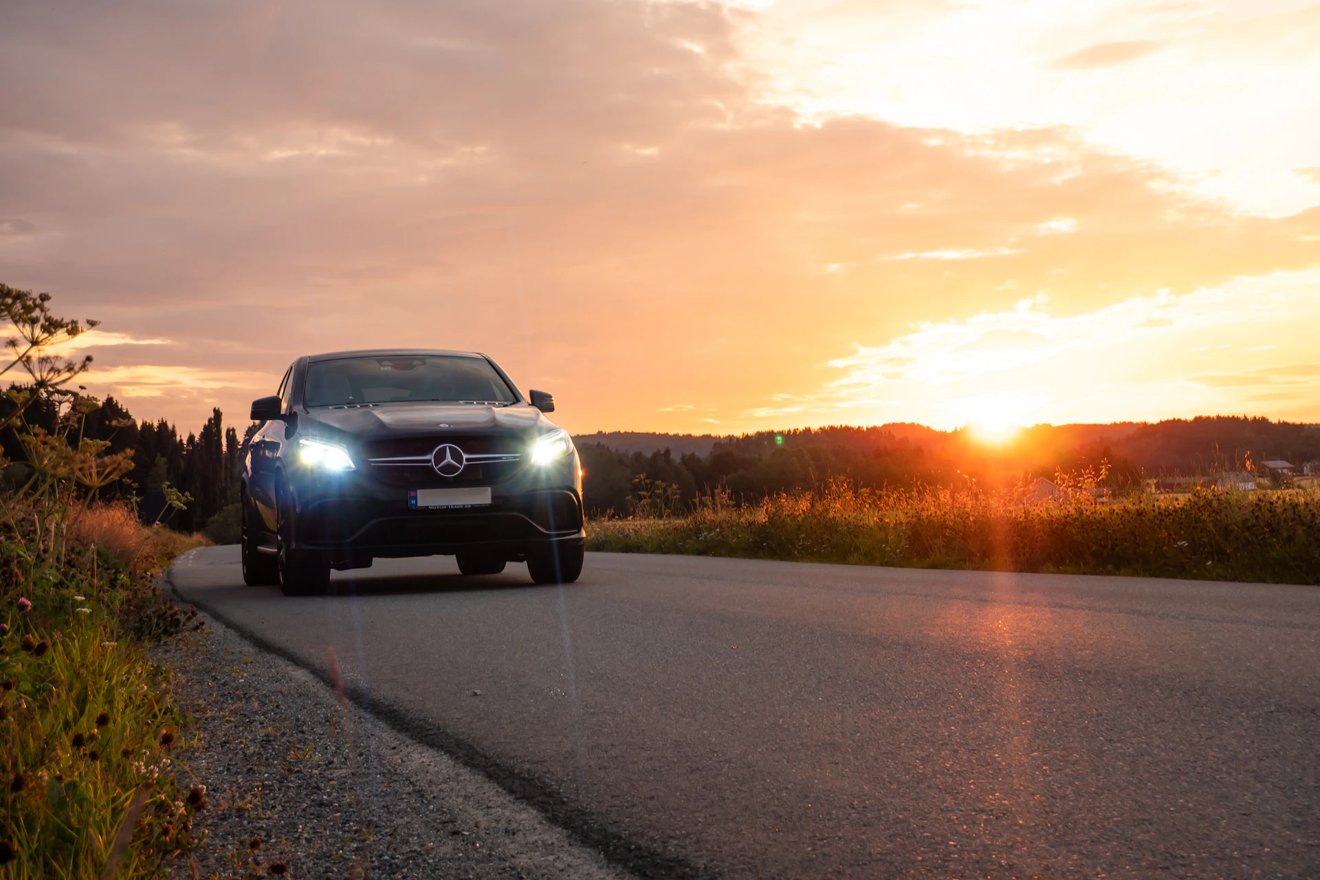 a car driving down a road at sunset