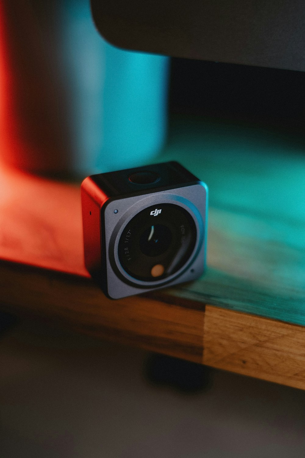 Eine kleine Kamera sitzt auf einem Holztisch