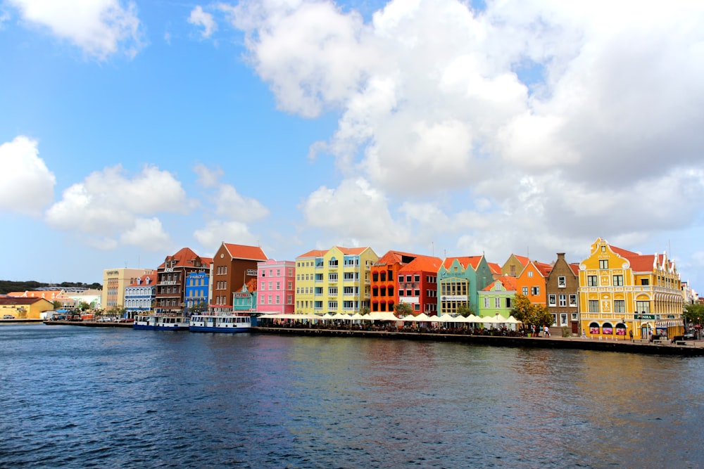 a row of colorful buildings on the side of a body of water