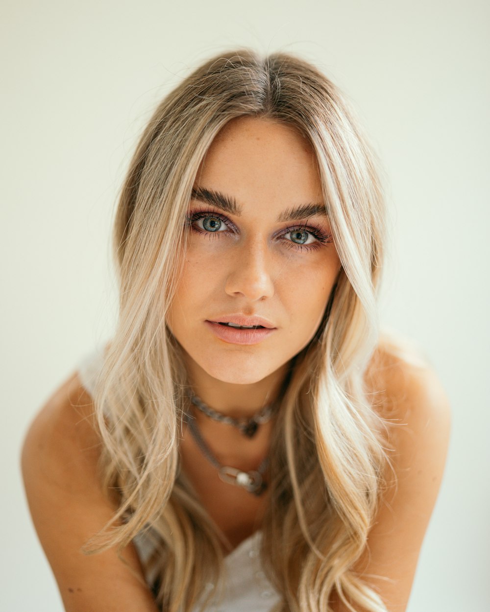 Una mujer con cabello largo y rubio con un collar