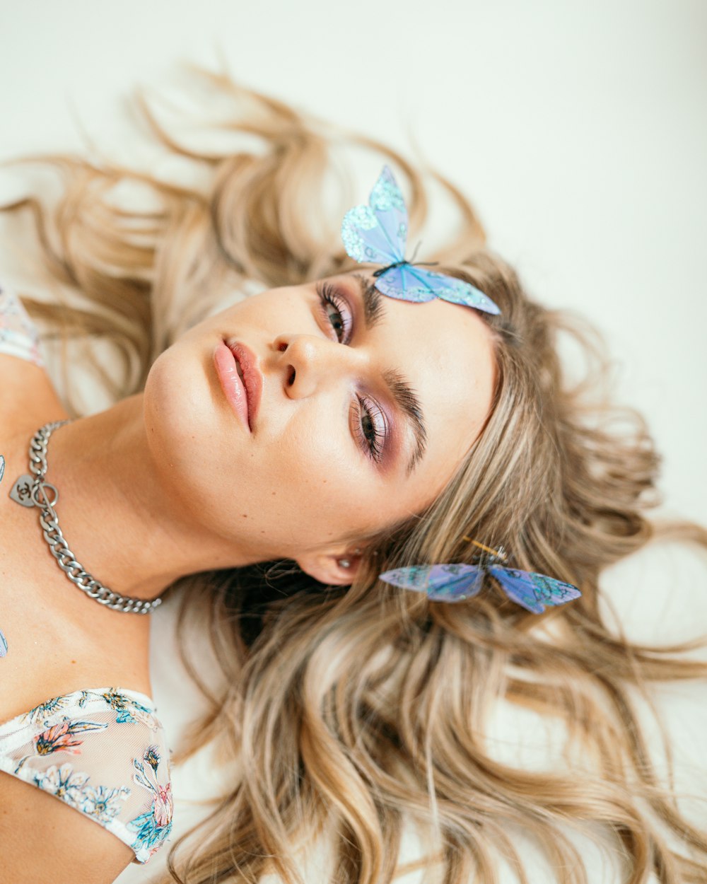 a beautiful young woman laying on top of a bed