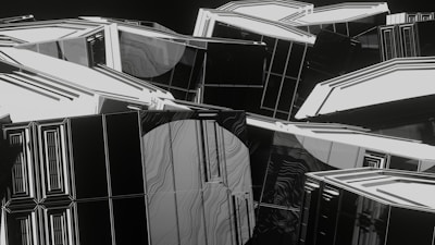 An abstract digital art piece featuring numerous geometric shapes and lines. The composition is dominated by white and black colors, with accents of gray, creating a high-contrast and modern look. The shapes appear to intertwine and overlap, giving a sense of depth and complexity.