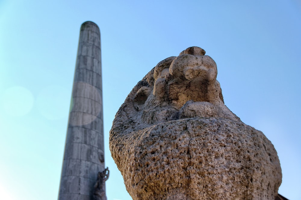 a statue of a bear is next to a tall pillar