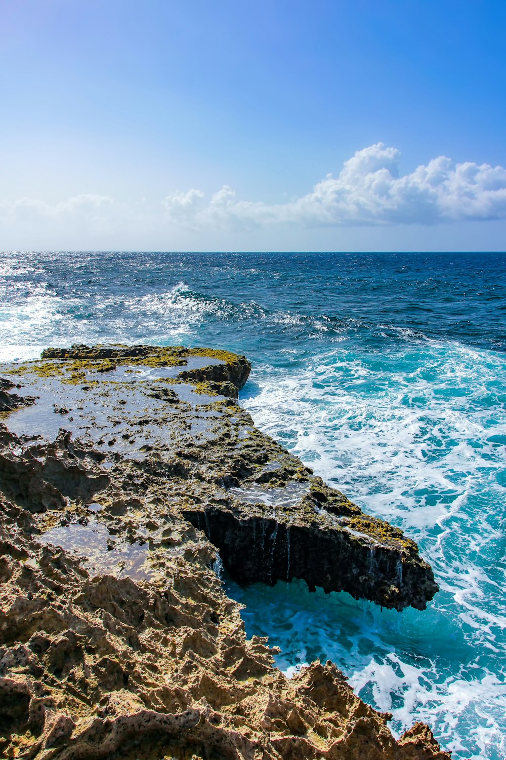 a rocky cliff with a body of water in the background