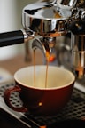 a cup of coffee being filled with liquid