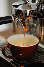 a cup of coffee being filled with liquid