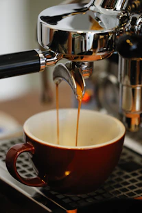 a cup of coffee being filled with liquid