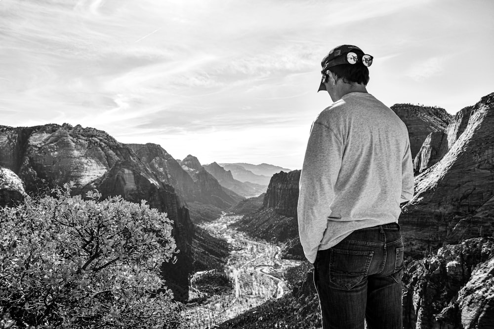 a man standing on top of a mountain overlooking a valley