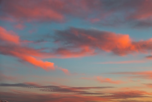 Soft, colorful clouds are scattered across the sky, with hues of pink and orange blending into a blue background.