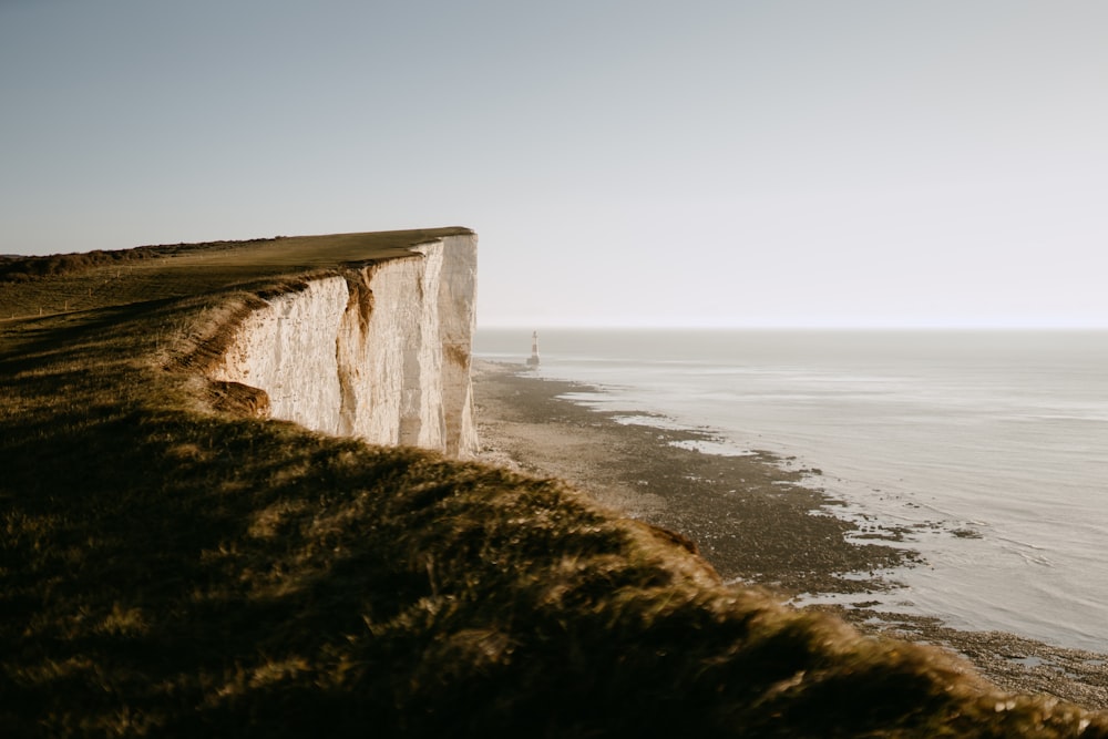 a large white cliff next to the ocean