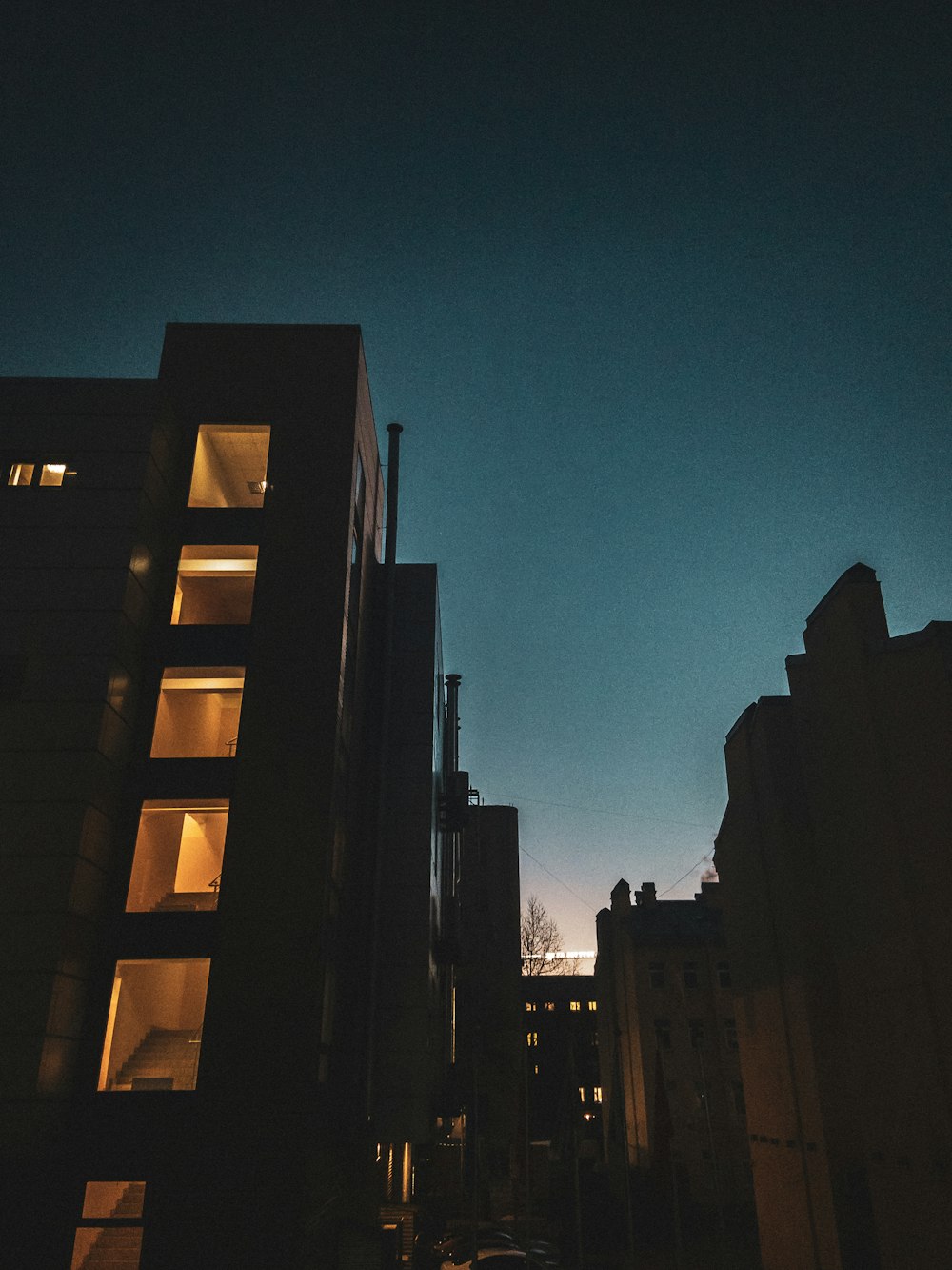 uma rua da cidade à noite com edifícios iluminados