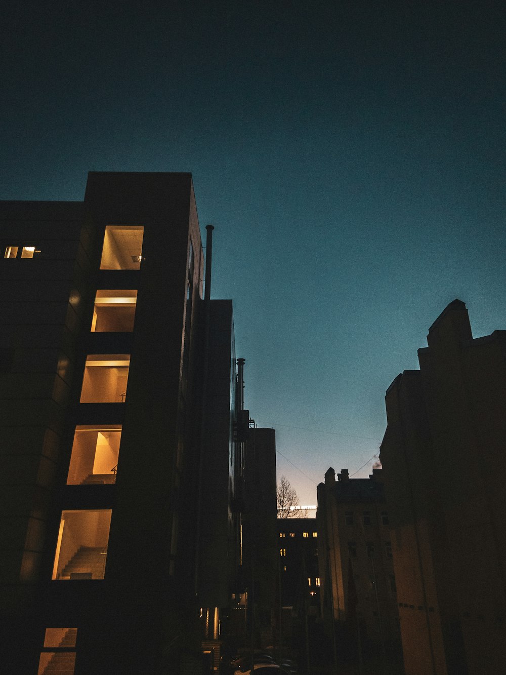 a city street at night with buildings lit up