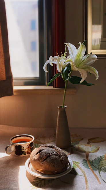 A serene morning scene with celbufi moisturizer beside a cup of herbal tea on a wooden table