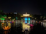 A scenic ornamental pond at sunset with water lilies and decorative lighting.