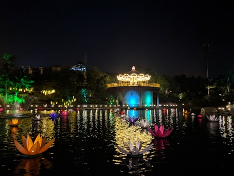 A scenic ornamental pond at sunset with water lilies and decorative lighting.