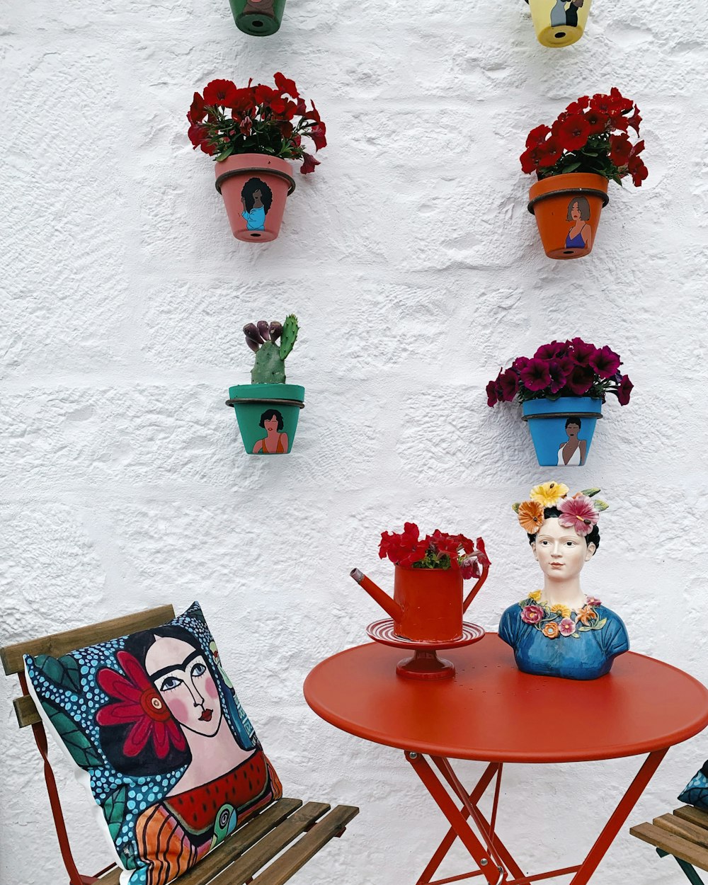 a red table with two chairs and a red table with flowers on it