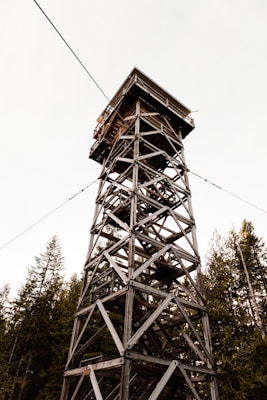 Fire lookout tower perched on mountain peak with panoramic views - wilderness greeting card design