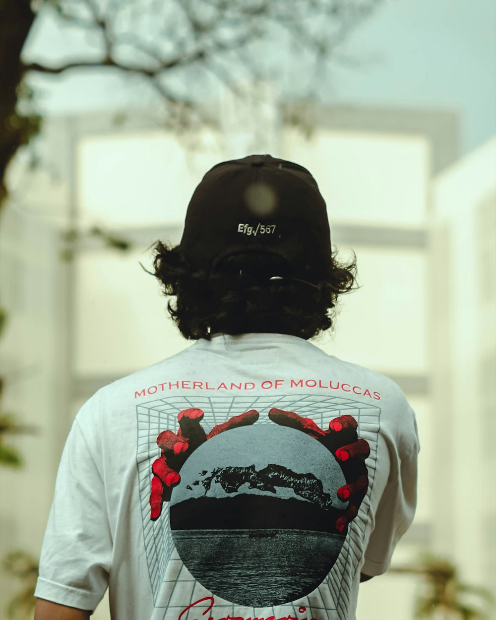 the back of a person wearing a t - shirt with a picture of a mountain