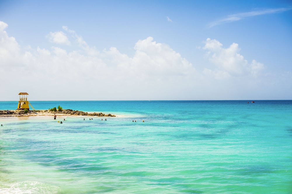 a view of a beach with people swimming in the water