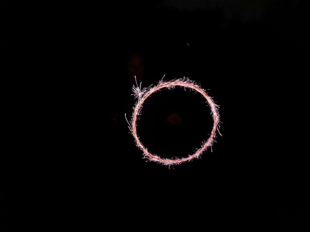 黒い背景にピンクの線香花火の輪